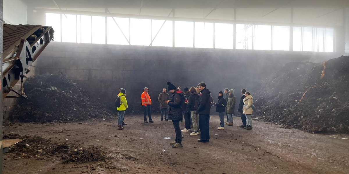 Die Exkursionsteilnehmenden zwischen dampfenden Komposthaufen in der Nachrottehalle